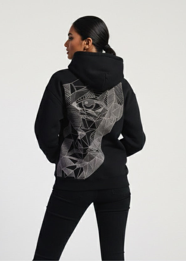 Person wearing a black hoodie with a geometric design on the back against a white background