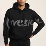Man wearing a black hoodie with 'GUESS' branding on a light background