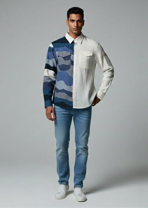 Man wearing a patterned shirt and jeans on a plain background