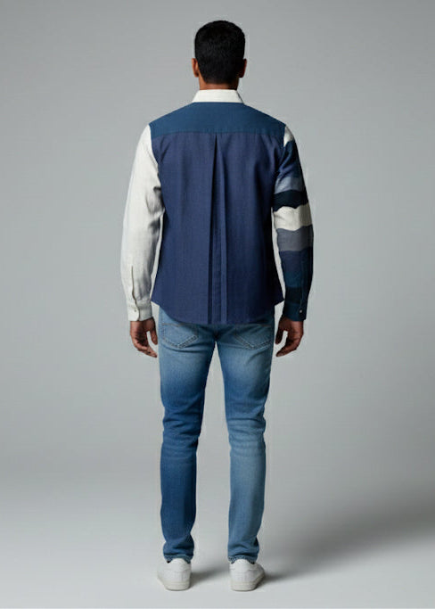 Person wearing a blue and white jacket with jeans on a gray background