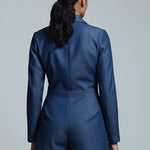 Person wearing a blue romper against a gray background