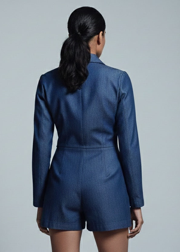 Person wearing a blue romper against a gray background