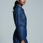 Woman wearing a blue outfit against a gray background