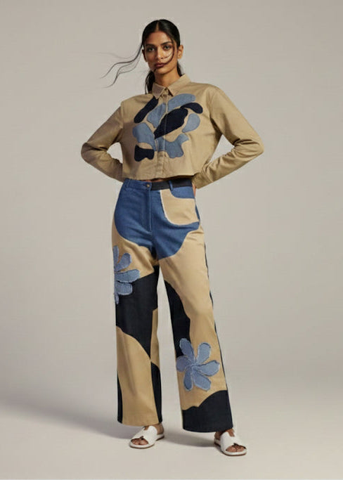 Person wearing a stylish outfit with a patterned sweater and pants on a plain background