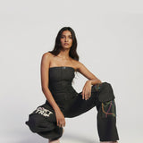Woman wearing black pants with text and colorful designs on a white background