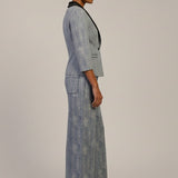 Woman wearing a gray patterned outfit on a plain background