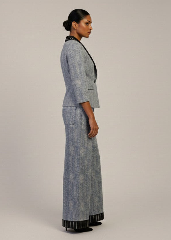 Woman wearing a gray patterned outfit on a plain background