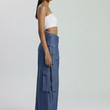 Woman wearing a white top and blue cargo pants on a white background