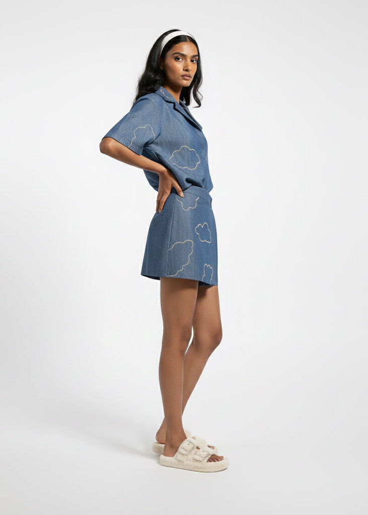 Woman wearing a blue denim outfit with cloud patterns on a white background