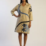 Woman wearing a beige dress with floral patterns on a white background