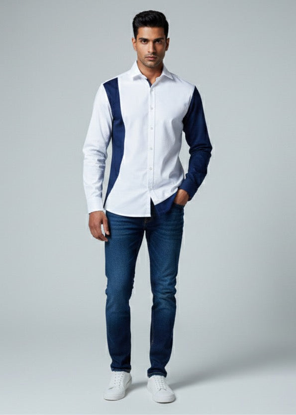 Man wearing a white shirt with navy accents and blue jeans on a gray background