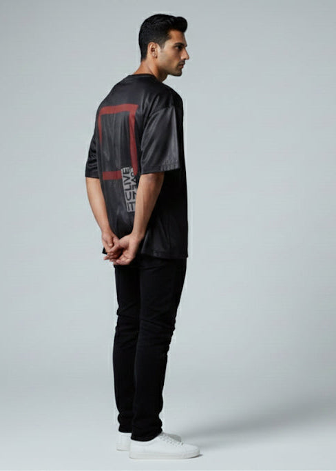 Man wearing a black and gray graphic t-shirt with black pants on a white background