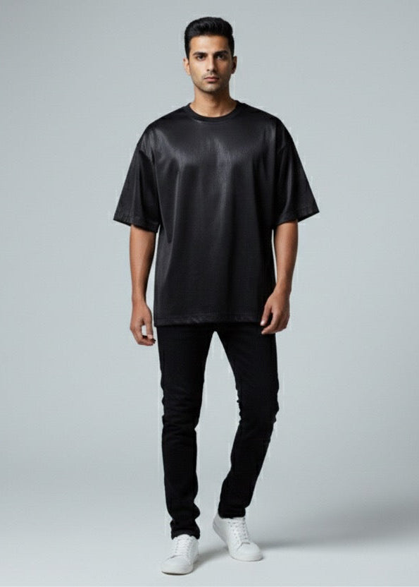 Man wearing a black satin shirt and pants on a gray background
