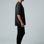 Man wearing a black outfit standing against a white background