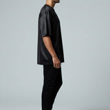 Man wearing a black outfit standing against a white background
