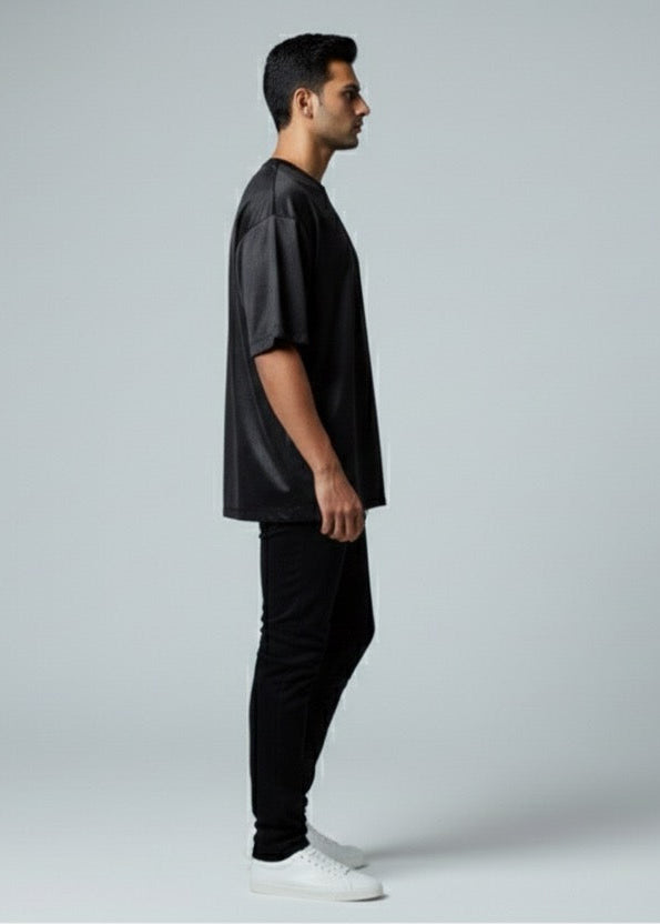 Man wearing a black outfit standing against a white background
