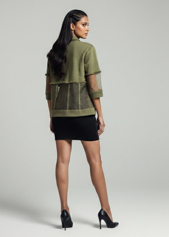 Woman wearing a green jacket and black skirt on a gray background