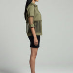 Woman wearing a green shirt and black skirt on a gray background