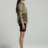 Woman wearing a green shirt and black skirt on a gray background