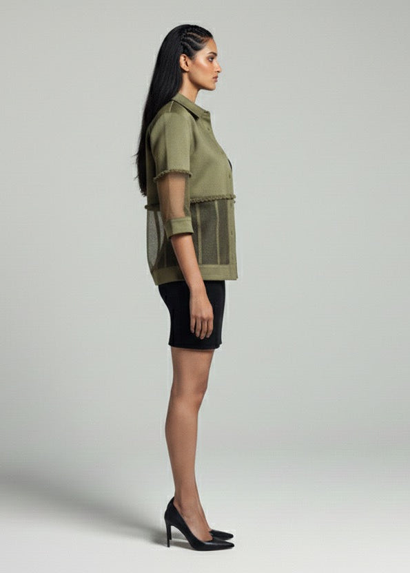 Woman wearing a green shirt and black skirt on a gray background