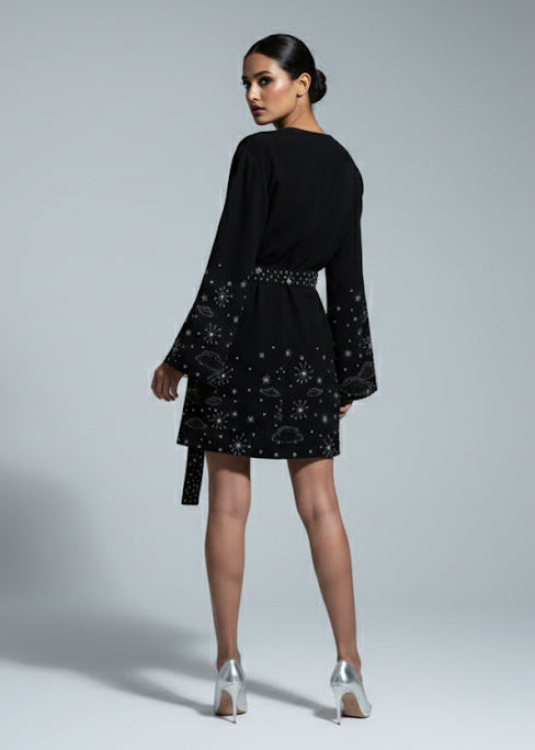 Woman wearing a black dress with star patterns on a gray background