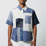 Man wearing a patterned shirt with geometric design on a plain background