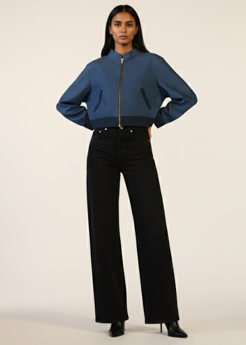Person wearing a blue jacket and black pants on a white background