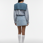 Person wearing a denim outfit with a white background