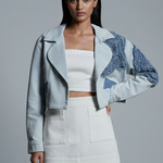 Woman wearing a stylish outfit with a textured jacket on a gray background