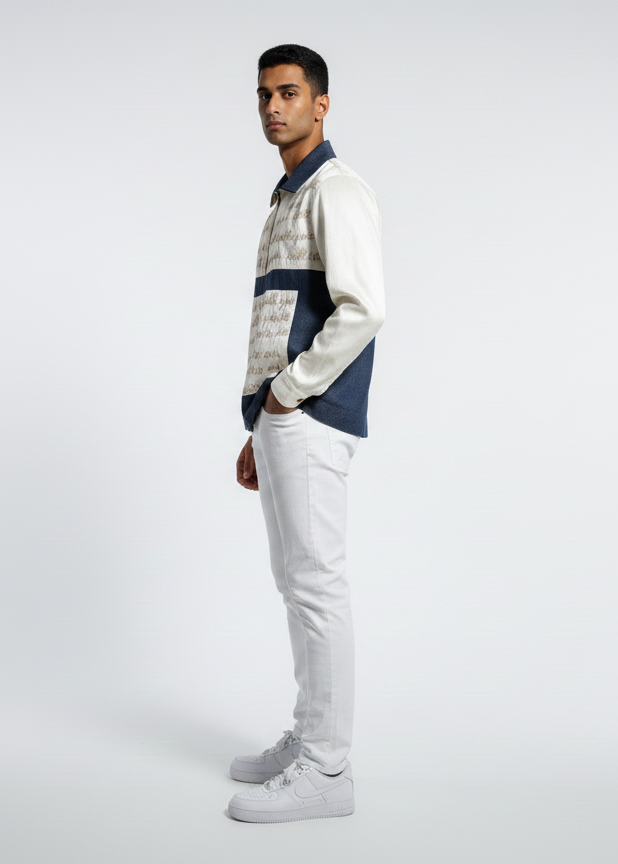 Man wearing a patterned shirt and light gray pants on a white background