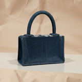Navy blue handbag on a beige background