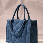 Blue quilted handbag on a neutral background