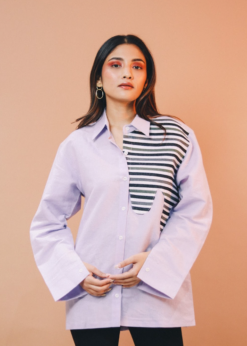 Woman wearing a light purple shirt with a striped pattern on a beige background